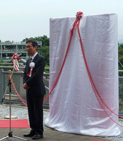 除幕前のモニュメントを前に挨拶する髙松工学部同窓会会長・工学部長